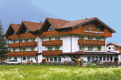 Hotel Villa Margherita z balkonami na tle górskiego krajobrazu.