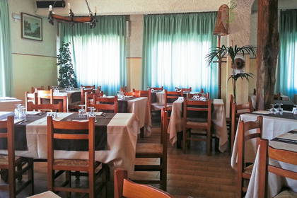 Wnętrze restauracji. Nakryte stoliki i drewniane krzesła.