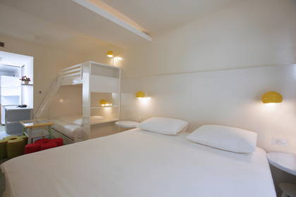 Pokój hotelowy z łóżkiem podwójnym i łóżkiem piętrowym.
