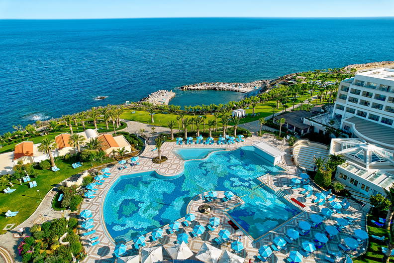 Hotel z basenem i morze w tle, widok z góry.