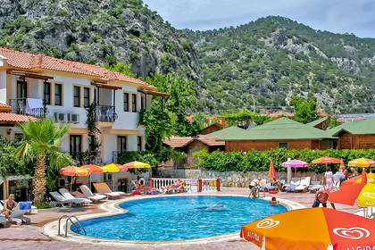 Kompleks hotelowy z basenem i widokiem na góry.