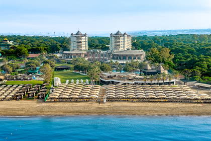 Widok z lotu ptaka na luksusowy hotel z plażą i parasolami.