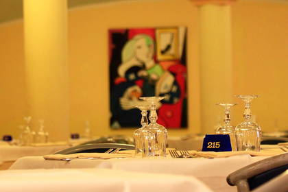 Sala restauracyjna z nakrytymi stołami. Widoczny numer stołu: 215.