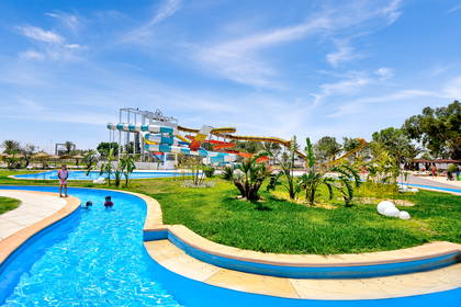 Park wodny ze zjeżdżalniami, rwącą rzeką i roślinnością.