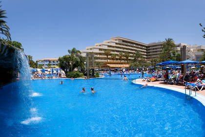 Basen w hotelu z wypoczywającymi osobami.