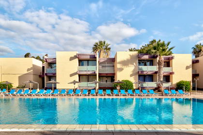 Hotel z basenem i leżakami do opalania.