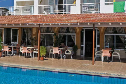 Basen hotelowy z tarasem i stolikami.