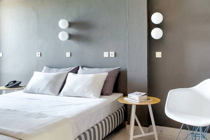 Pokój hotelowy z łóżkiem, krzesłem i balkonem.