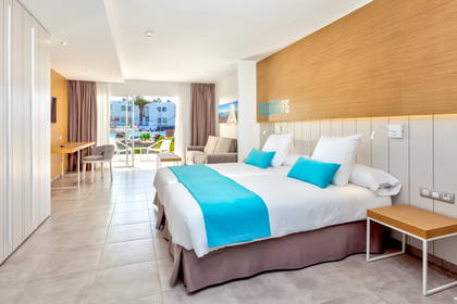 Pokój hotelowy z dwoma łóżkami, widokiem na basen i napisem "Happiness" na ścianie.