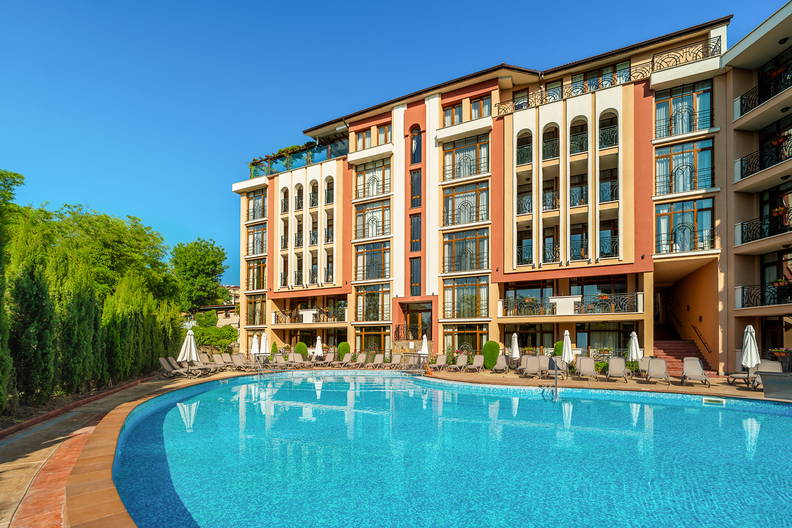 Wielopiętrowy budynek hotelu z basenem z przodu.