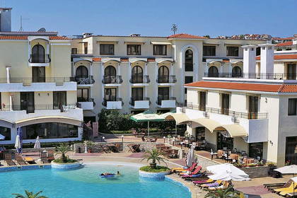 Kompleks hotelowy z basenem, leżakami i parasolami.