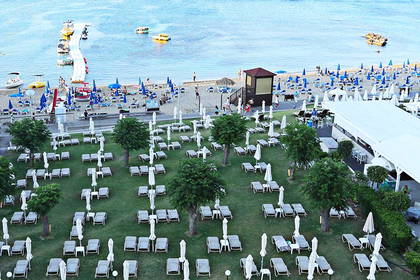 Plaża z lotu ptaka. Widoczne leżaki i parasole.