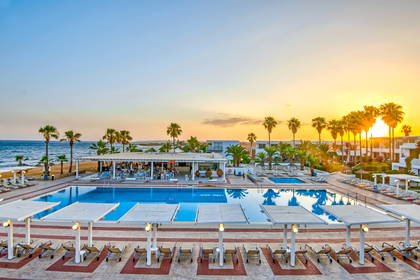 Hotelowy basen i bar na plaży o zachodzie słońca.