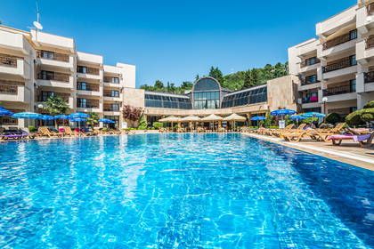 Basen z leżakami i parasolami przy hotelu.