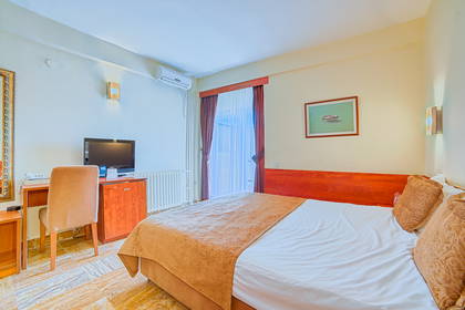 Pokój hotelowy z łóżkiem, biurkiem i telewizorem.