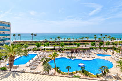 Hotelowy basen z palmami i morzem w tle (widok z góry).