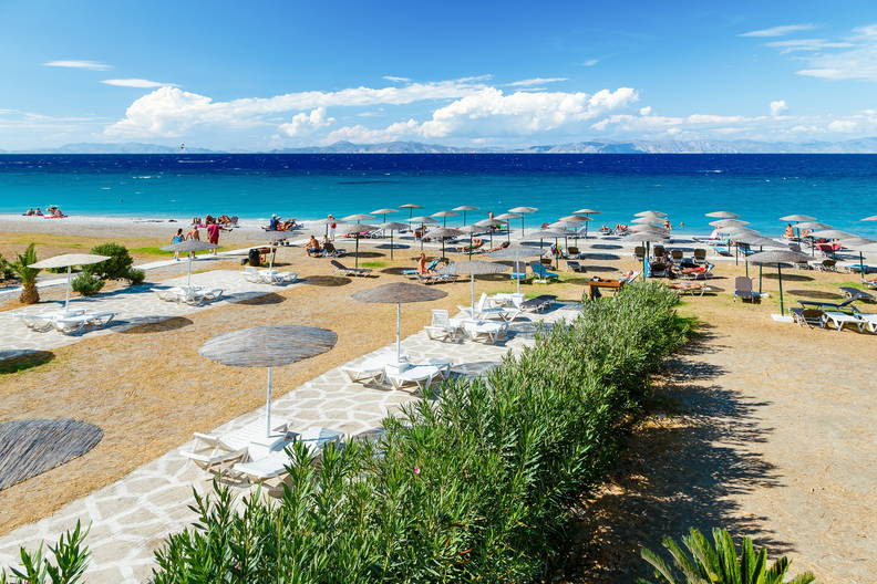 Plaża z parasolami i leżakami widziana z góry.