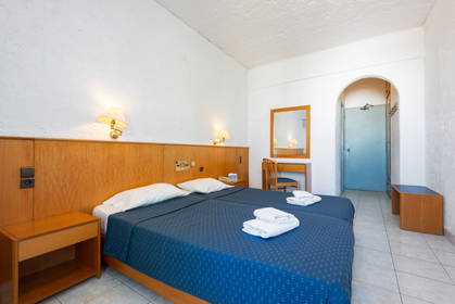 Pokój hotelowy z dwoma łóżkami, biurkiem i niebieskimi drzwiami.