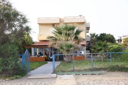 Trzypiętrowy budynek z restauracją blisko plaży.