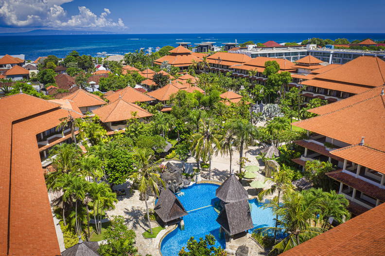 Kurort z basenem i palmami, widok z góry.