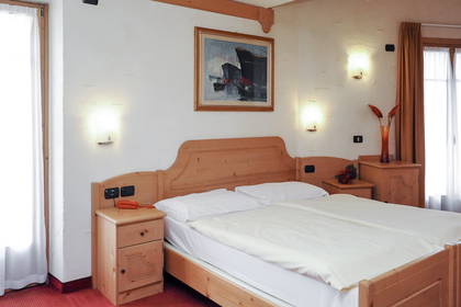 Drewniane łóżko w pokoju hotelowym.