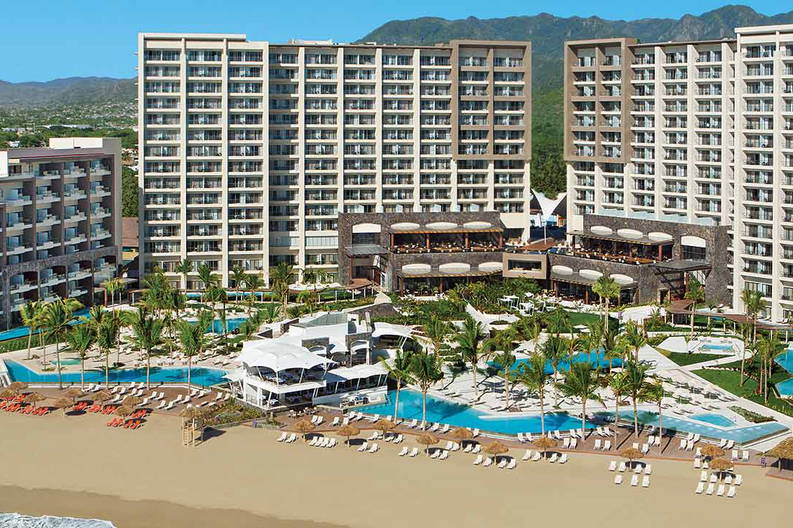 Luksusowy kurort z basenami i palmami na plaży.