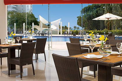 Restauracja z widokiem na basen i leżaki.