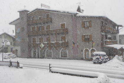 Hotel zasypany śniegiem w zimowej scenerii.