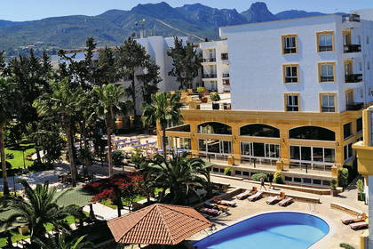 Hotel z basenem i palmami. W tle góry. Widok z góry.