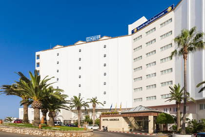 Biały budynek hotelu America z palmami na tle błękitnego nieba.