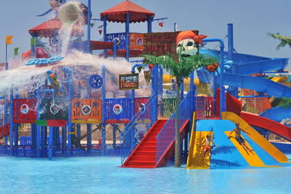 Kolorowy park wodny w stylu pirackim z dziećmi zjeżdżającymi ze zjeżdżalni.