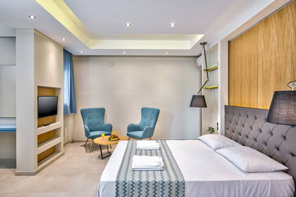 Pokój hotelowy z łóżkiem i fotelami.