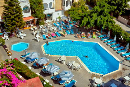 Widok z góry na basen hotelowy z leżakami i parasolami.