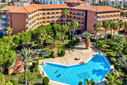 Hotel z basenem i palmami, widok z góry.