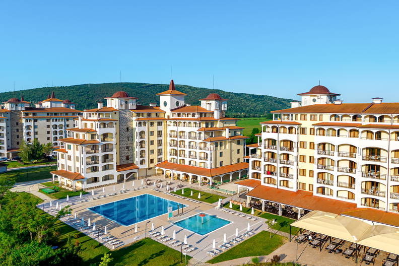 Luksusowy hotel z basenami otoczony zielenią, widok z góry.