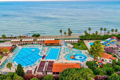Resort wypoczynkowy z basenami i plażą, widok z góry.