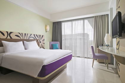 Pokój hotelowy z łóżkiem, biurkiem i oknem.
