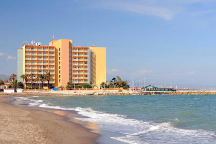 Hotel na plaży, fale uderzają o brzeg.