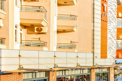 Hotelowy basen z leżakami i restauracją. W tle widok na morze.
