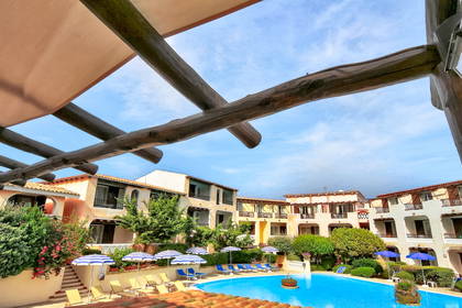 Basen hotelowy widziany spod drewnianego zadaszenia.