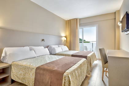 Pokój hotelowy z dwoma łóżkami, biurkiem i balkonem.