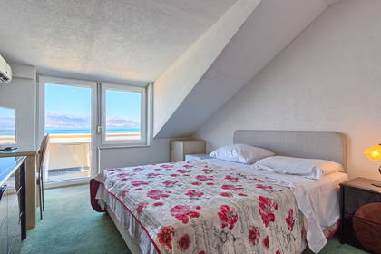 Pokój hotelowy na poddaszu z widokiem na morze.