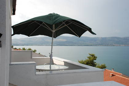 Balkon z parasolem i widok na morze.