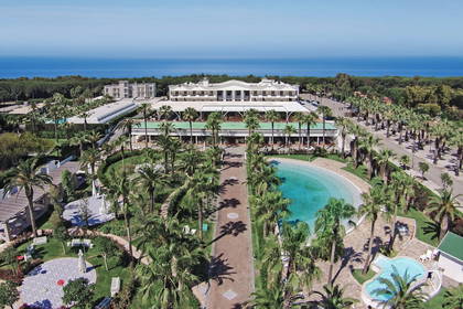 Hotel z basenem i palmami, widok z lotu ptaka.