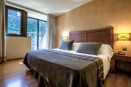 Pokój hotelowy z dużym łóżkiem i widokiem na góry.