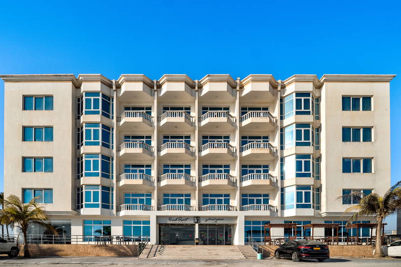 Hotel z balkonami i niebieskimi oknami.