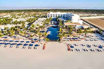 Kurort z lotu ptaka: plaża, basen i palmy.