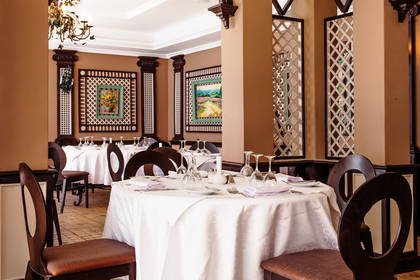 Restauracja z nakrytymi stołami i drewnianymi krzesłami.