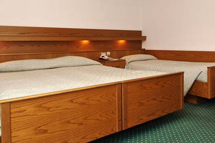 Pokój hotelowy z dwoma łóżkami i fotelem.