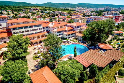Hotel z basenem otoczony zielenią, widok z góry.